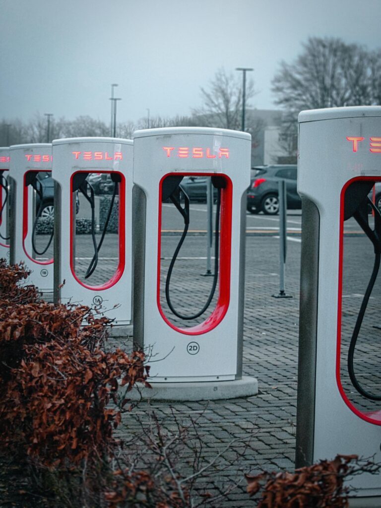 Line of Tesla charging stations in a misty urban environment, ready for electric vehicles.